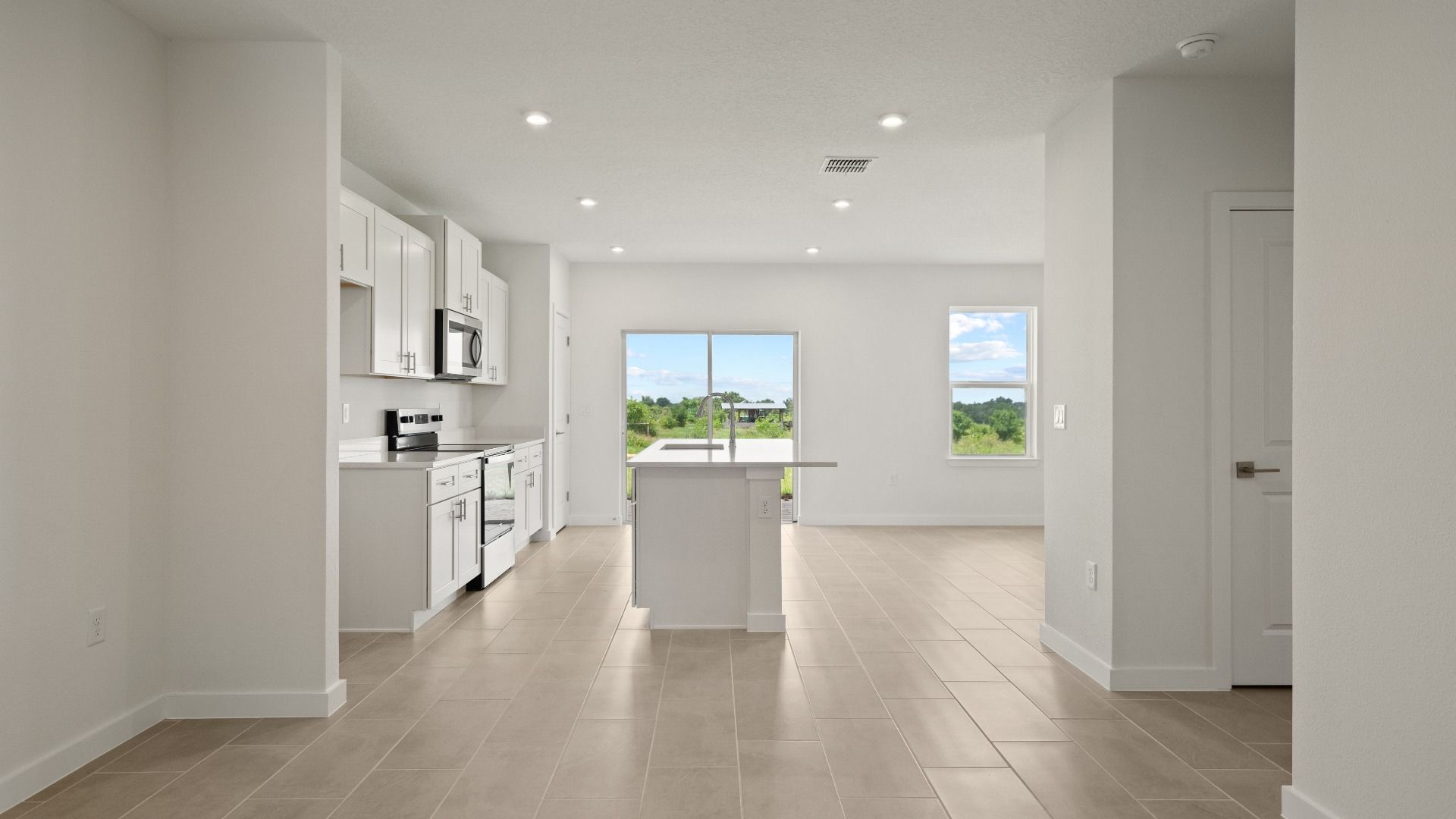 Bright and open-concept kitchen flows into great room with sleek finishes and beautiful backyard views