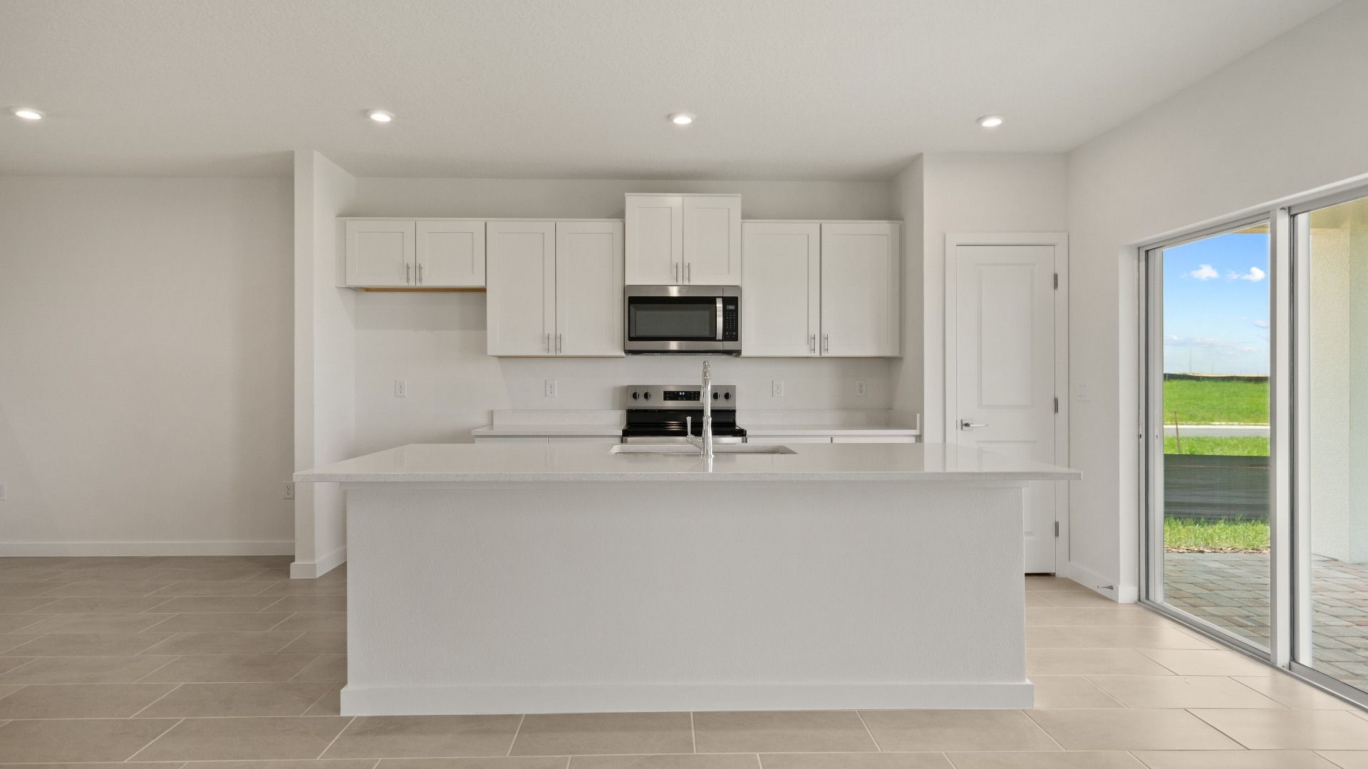 Open kitchen with a large island, natural light, and direct access to the backyard—perfect for cooking and entertaining