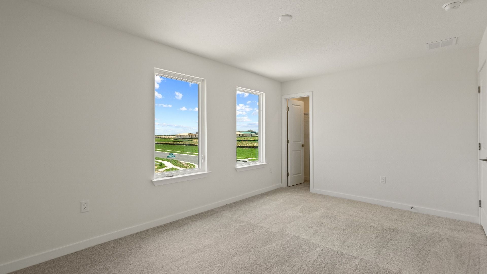 Spacious second bedroom with soft carpeting and great natural light—ideal for guests, kids, or a cozy retreat