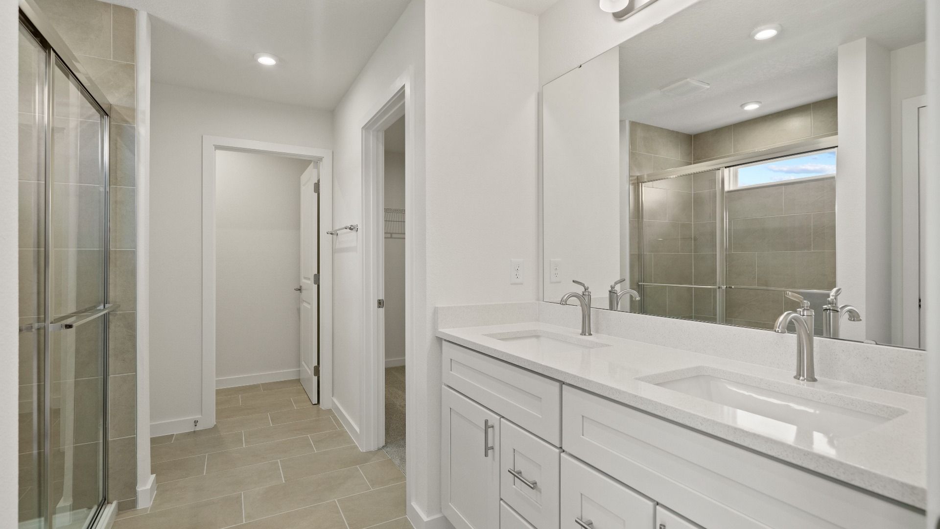 Elegant primary bath features a spacious double vanity, glass shower, and sleek finishes for a relaxing retreat