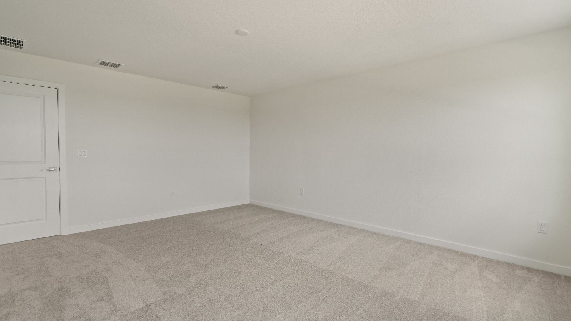 Expansive primary suite offers comfort and privacy with soft carpet, generous layout, and attached ensuite bath