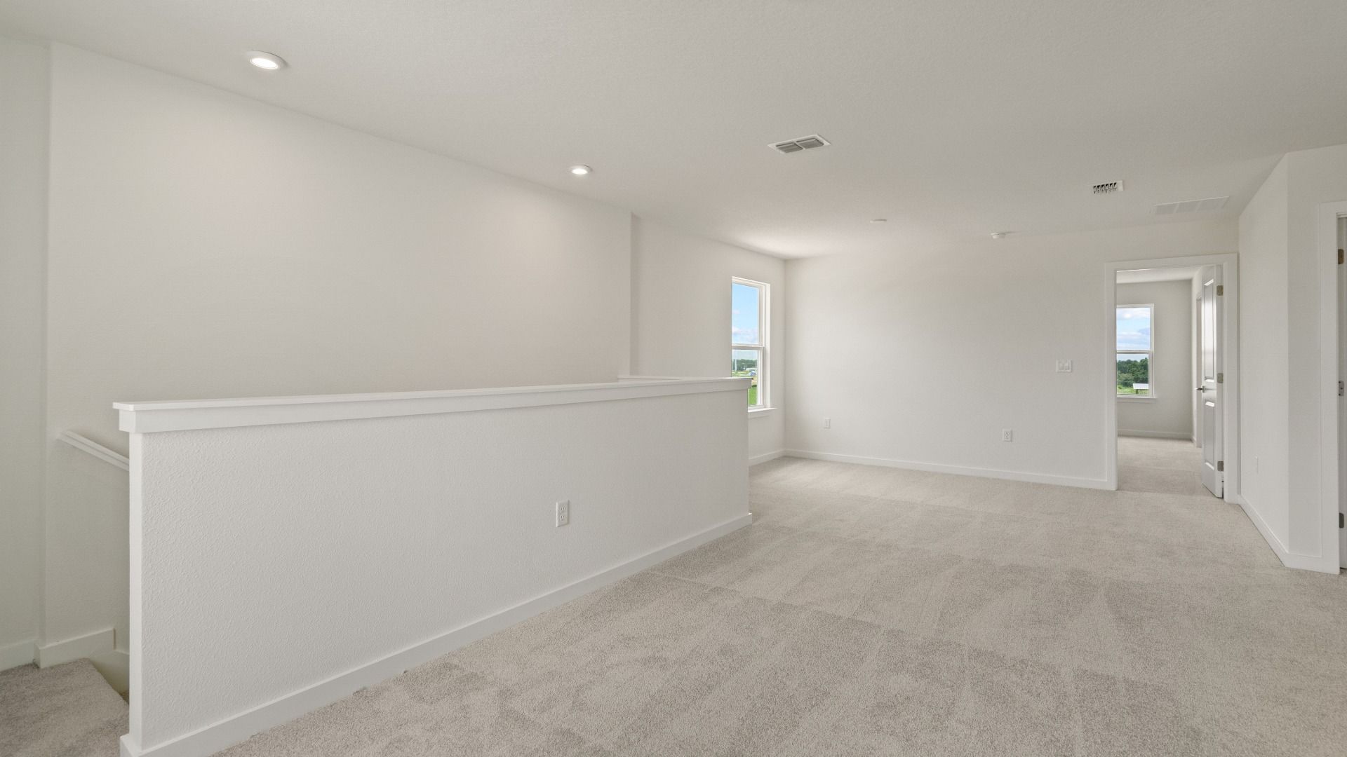 Bright and open upstairs landing connects living spaces, offering flexibility for a reading nook, desk, or lounge area