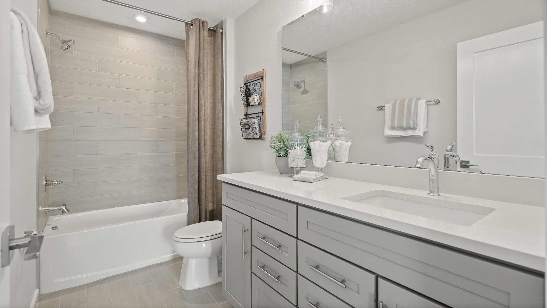 Stylish secondary bathroom with tile tub surround in the new construction Jupiter Model at Grasslands West by DRB Homes.