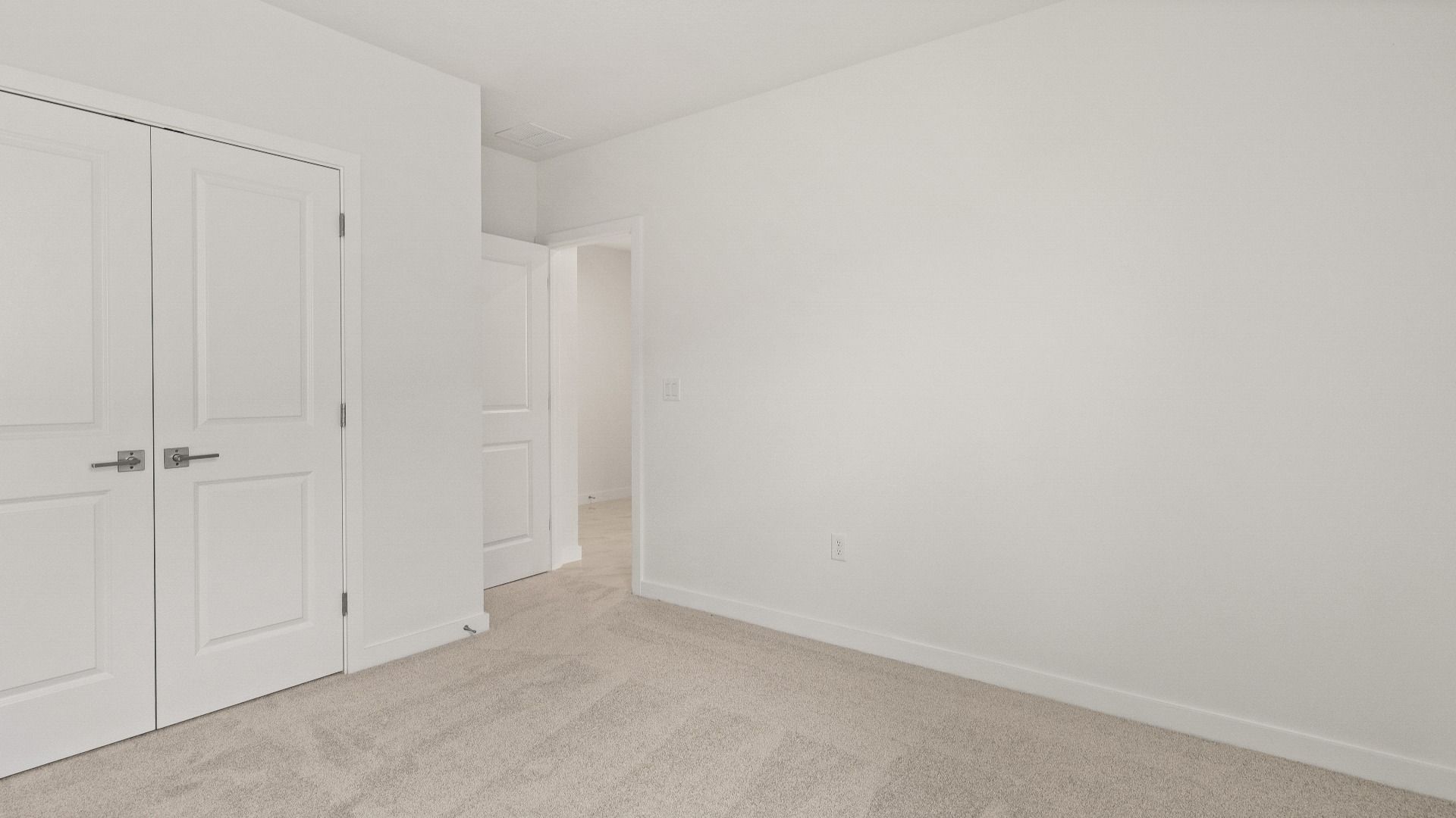 Bedroom with plush carpet and double-door closet in the Castaway model by DRB Homes