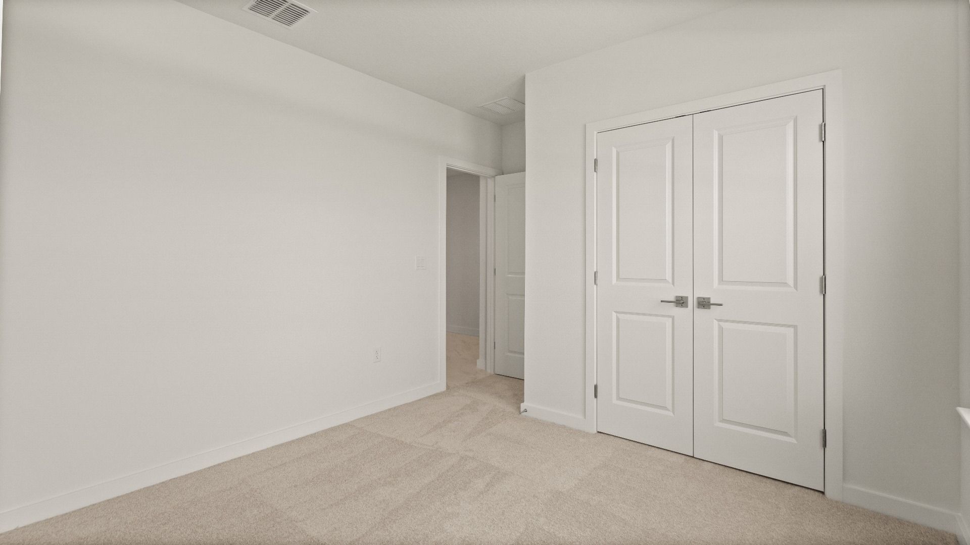 Spacious bedroom with plush carpet and double-door closet in the Castaway model