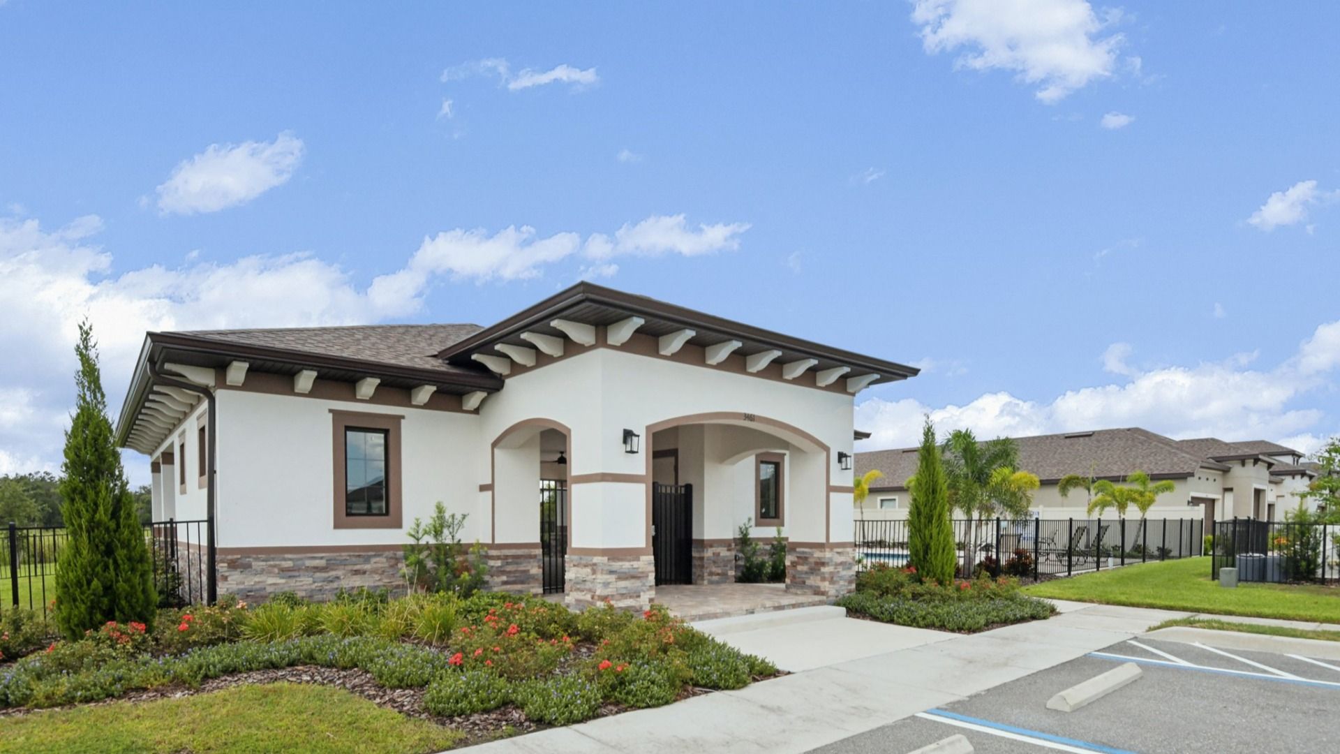 Grasslands West community clubhouse with modern architecture, landscaped entry, and resort-style amenities by DRB Homes.