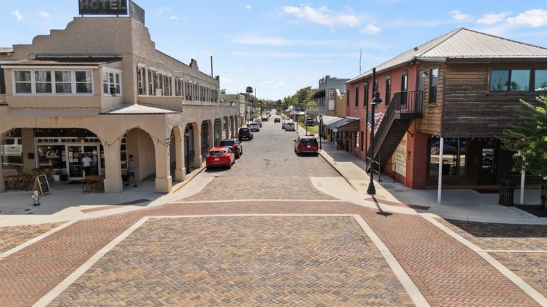 Brick-paved street with historic buildings in downtown St. Cloud, FL, offering charm and character near Cyrene at Harmony.