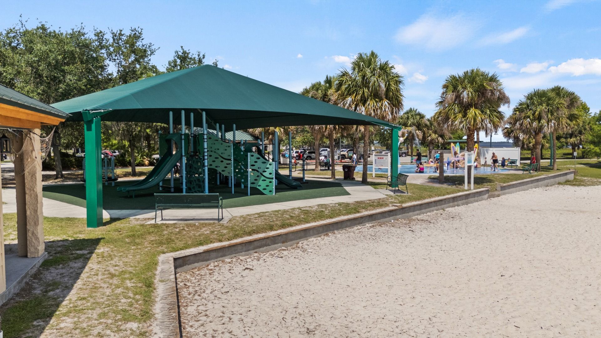 Shaded playground at Lakefront Park in St. Cloud, FL with splash pad and beach area nearby, minutes from Cyrene at Harmony.