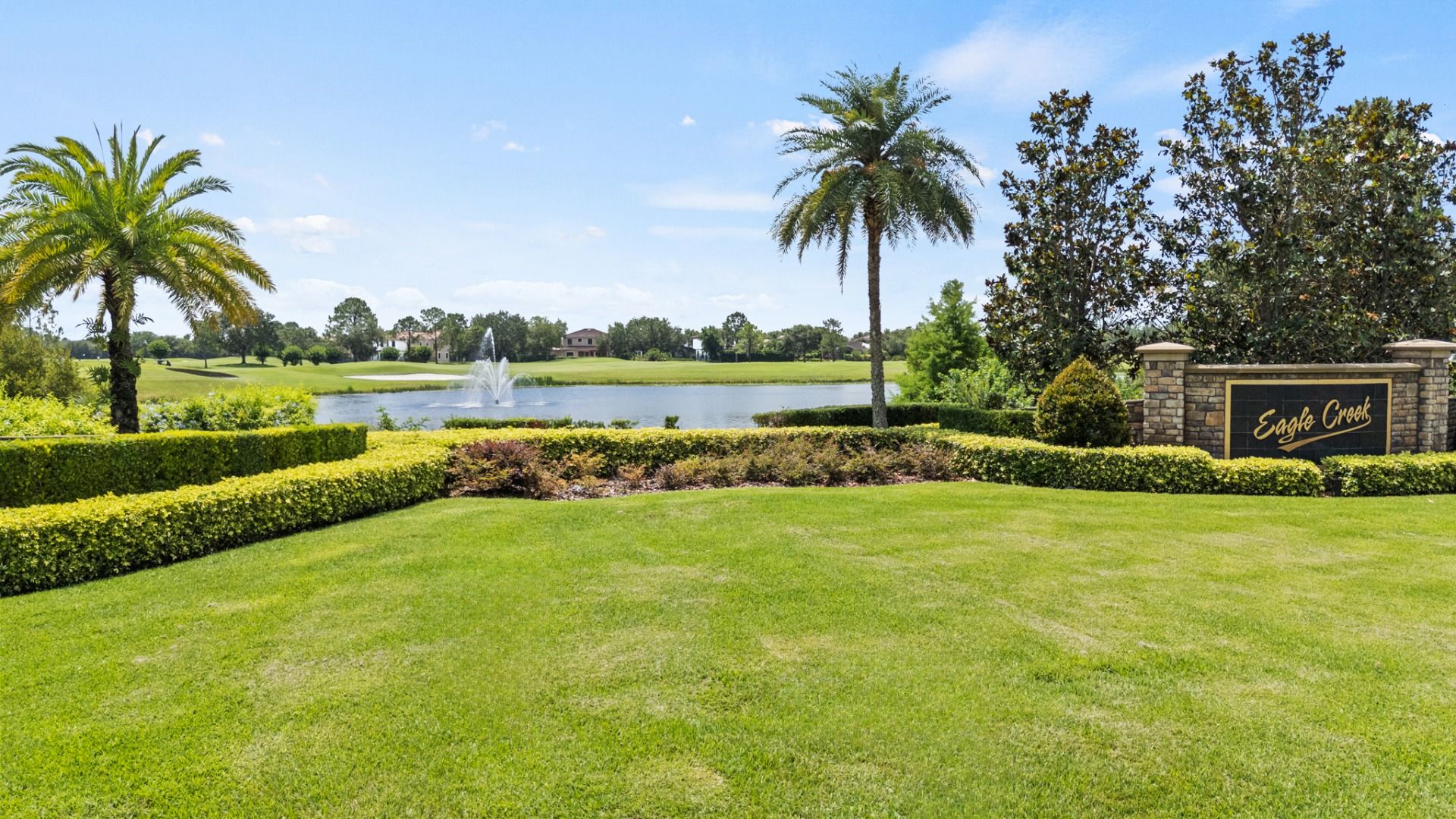 Eagle Creek Golf Course community entrance in Lake Nona, FL with lush landscaping and beautiful lake near Cyrene at Harmony.
