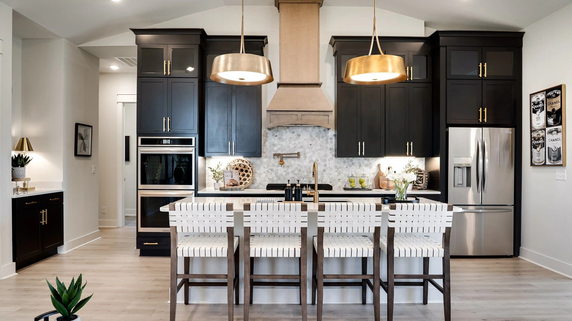 Dark cabinetry, marble backsplash, and brass fixtures define this Shelton Square kitchen’s sophistication.