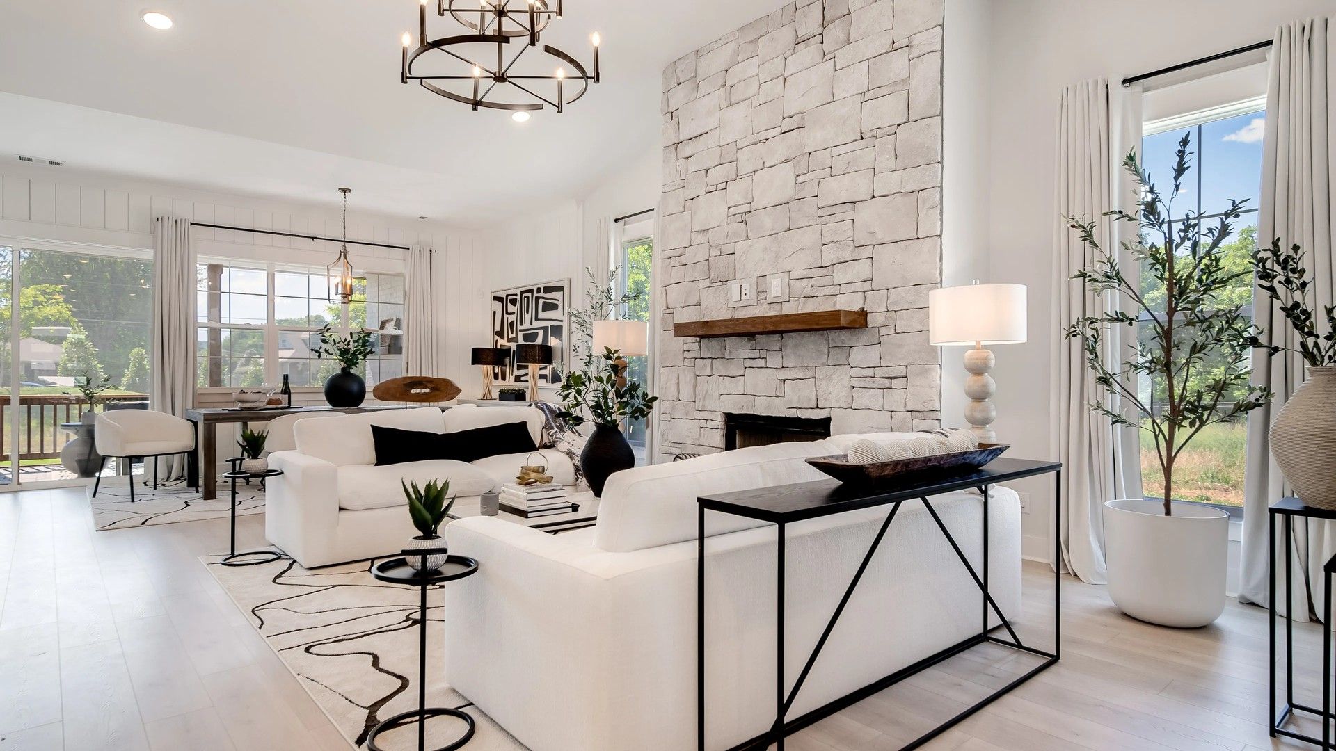 Majestic stone fireplace anchors the living space, enhanced by an exquisite chandelier. Shelton Square elegance.