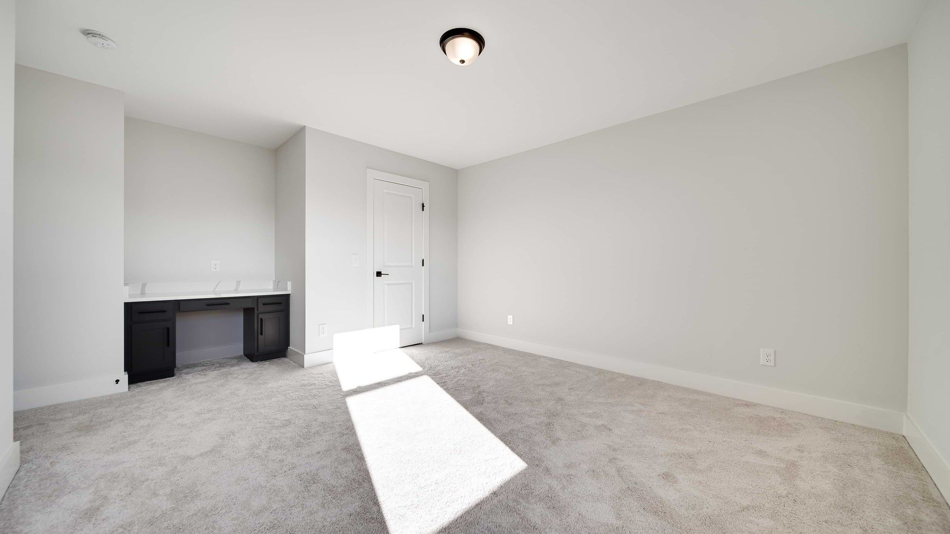 Experience luxury with this sunlit room's sleek built-in desk and plush carpet in Richvale Estates.