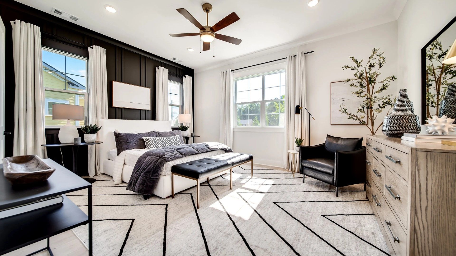 Shelton Square bedroom boasts chic black accent wall, elegant furnishings, and expansive natural light.