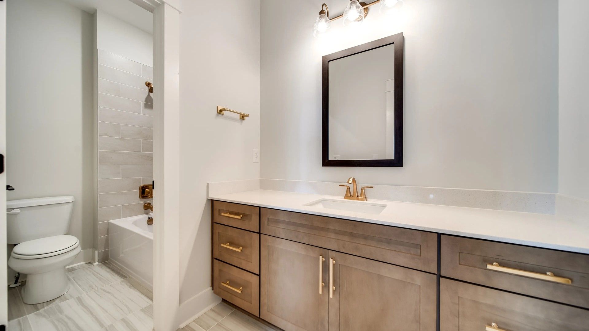 Experience luxury with a sophisticated vanity, chic gold finishes, and exquisite marble tile in Shelton Square.