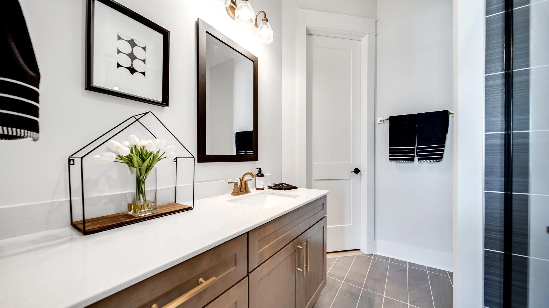 Experience luxury with a dark wood vanity and quartz counter in Shelton Square’s refined bathroom.