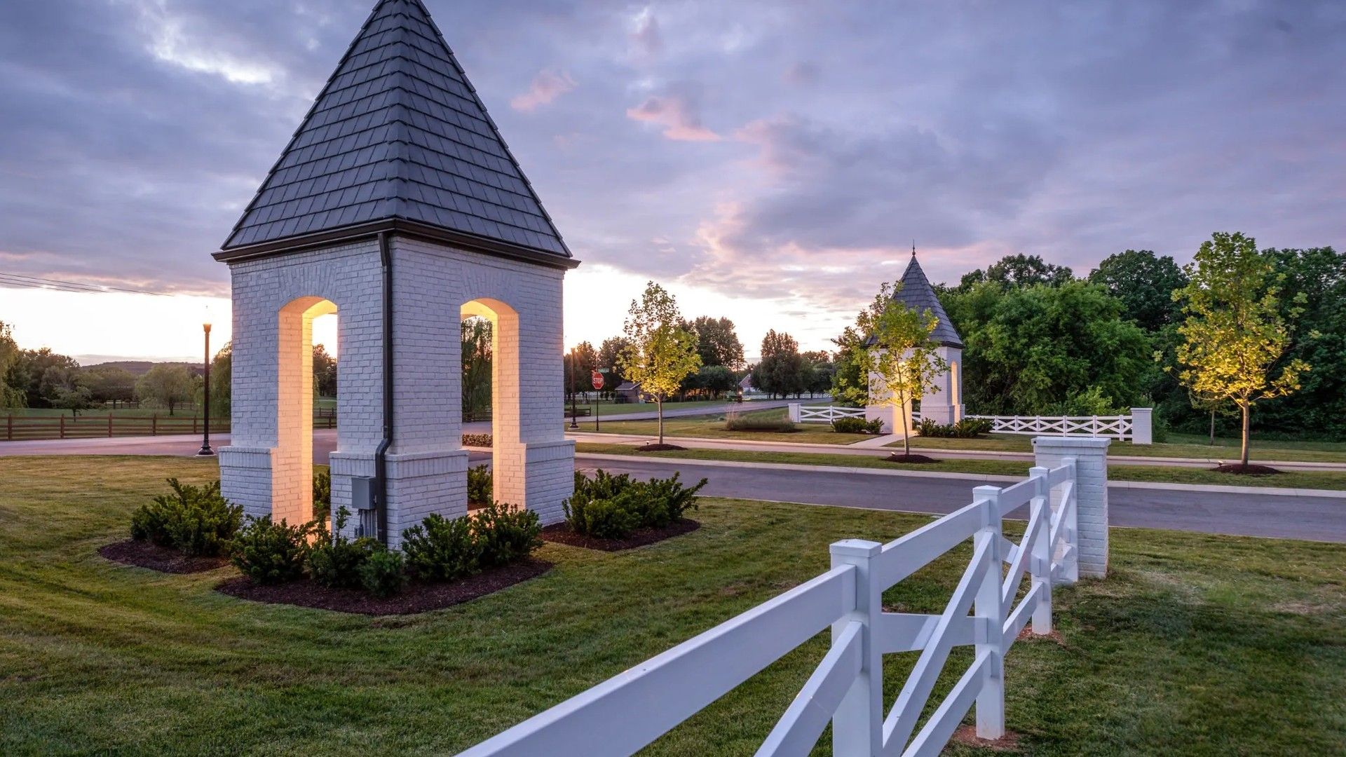 Luxurious white brick towers with slate roofs exude timeless elegance amidst lush Shelton Square landscape.