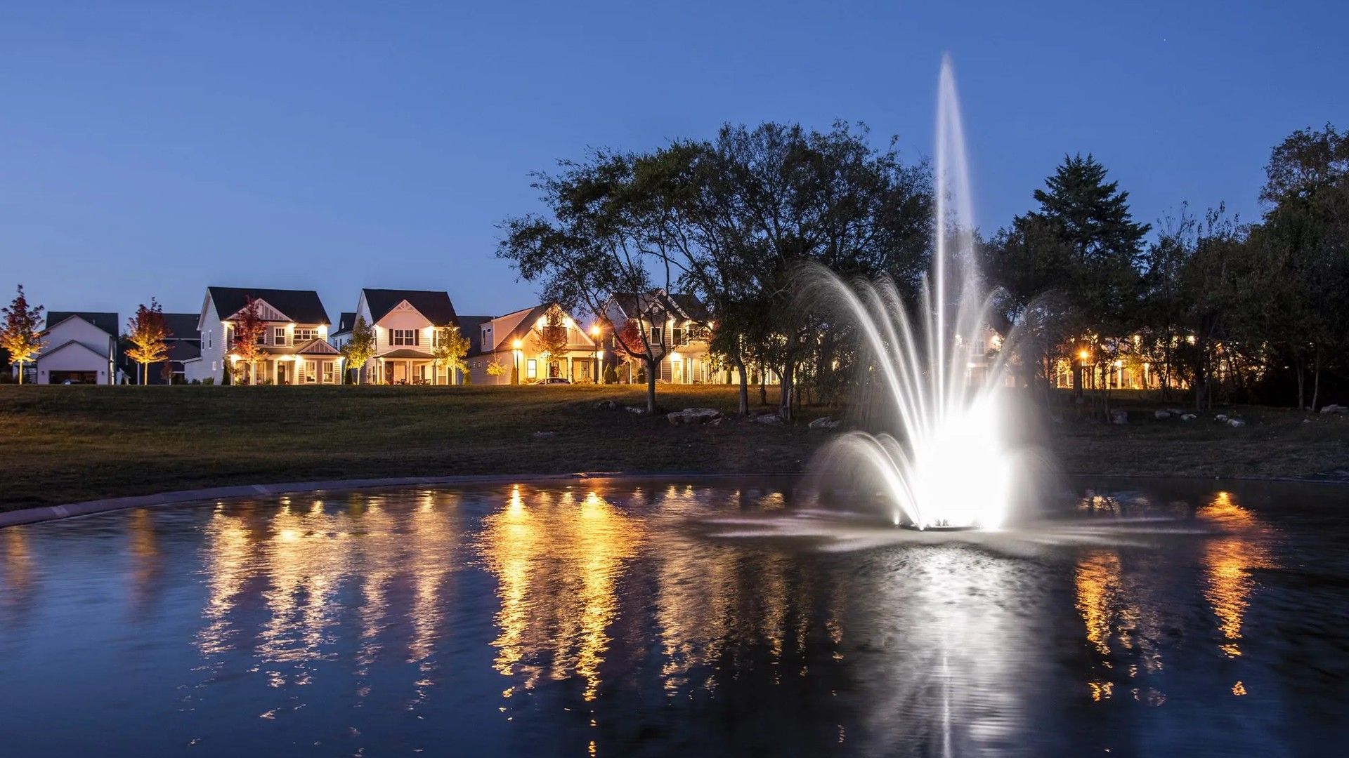 Revel in Shelton Square's enchanting atmosphere, featuring stately homes and a luminous fountain display.