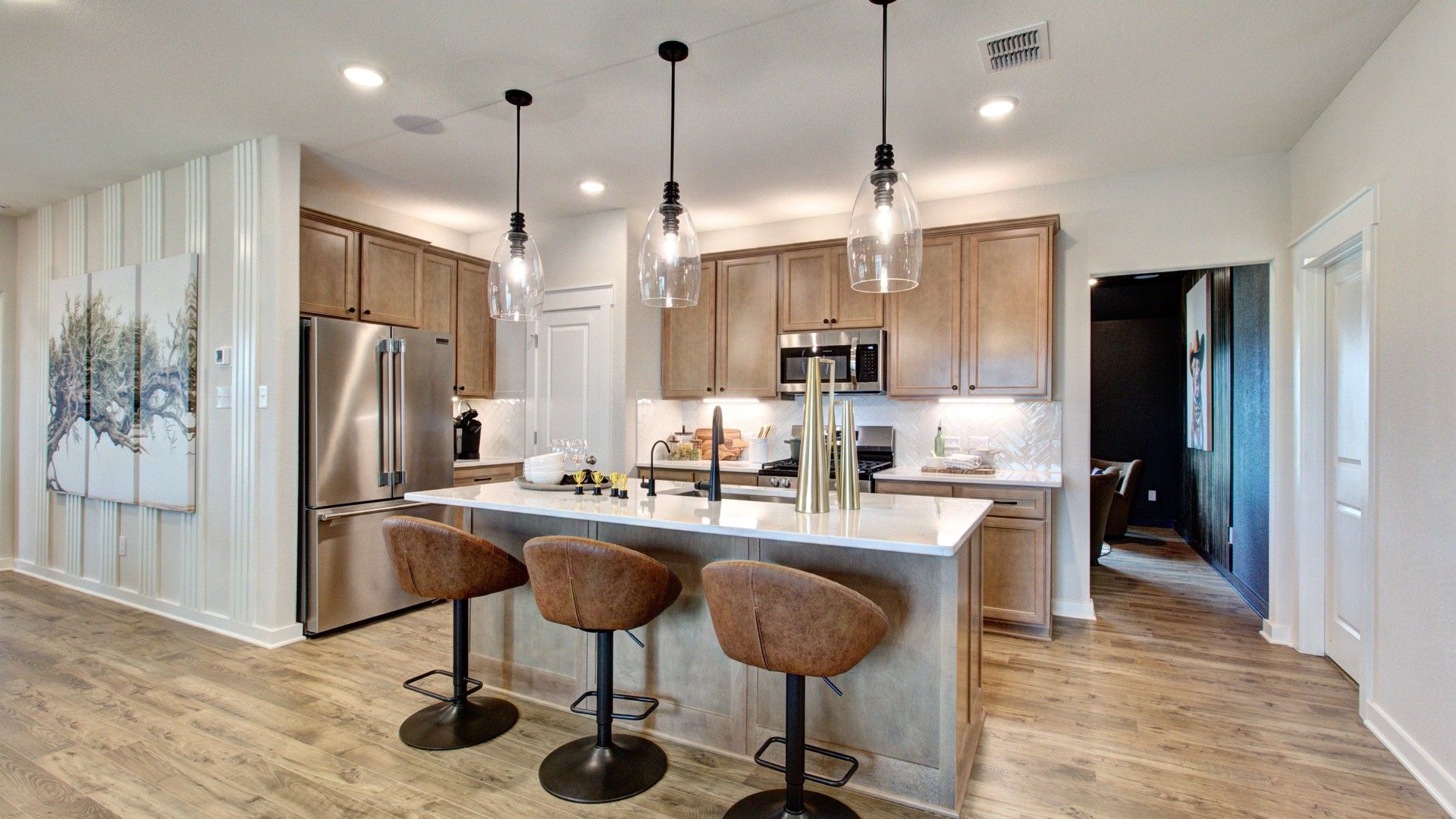 Elegant pendant lighting and chic cabinetry elevate the Prairie Green kitchen ambiance.