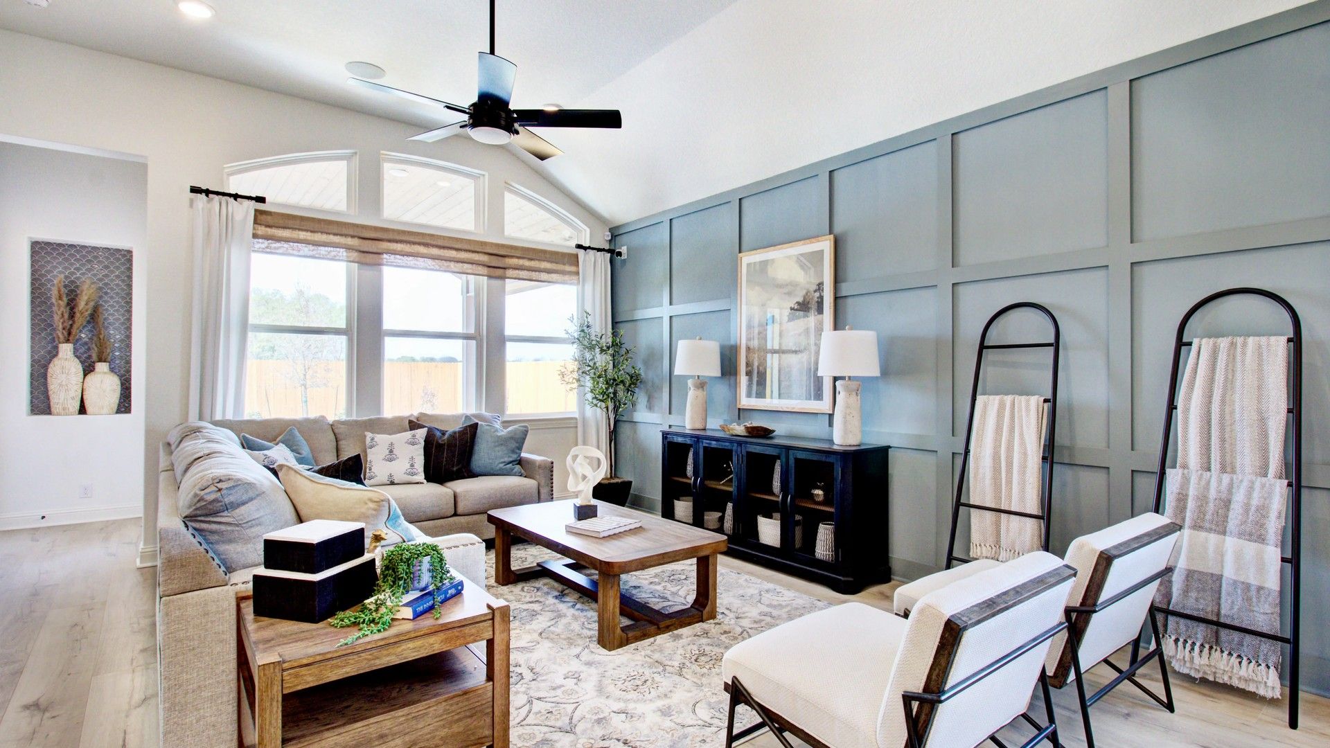 Experience elegance with vaulted ceilings and stylish wainscoting in Veranda's luxurious living room.