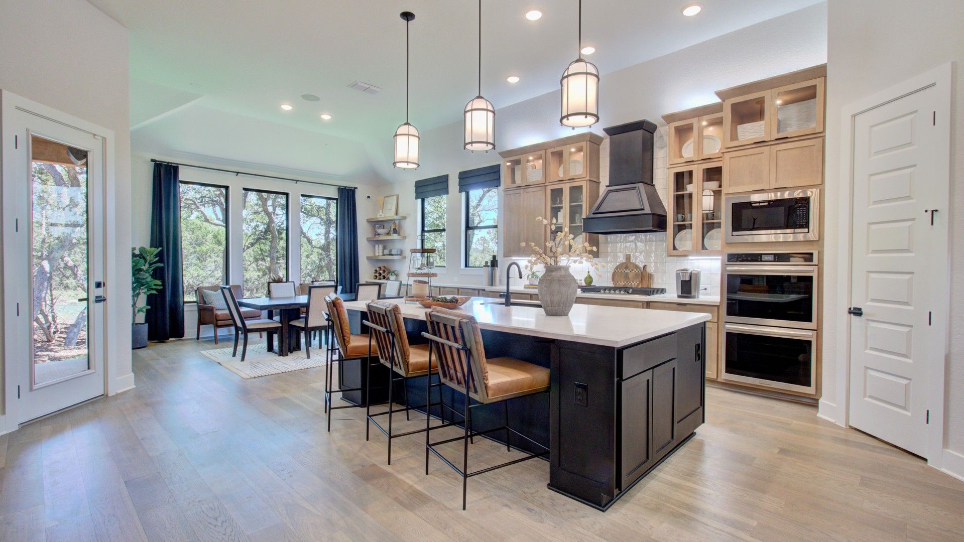 Elegant kitchen with wood flooring, chic island, and scenic windows in Verandas at the Rim.