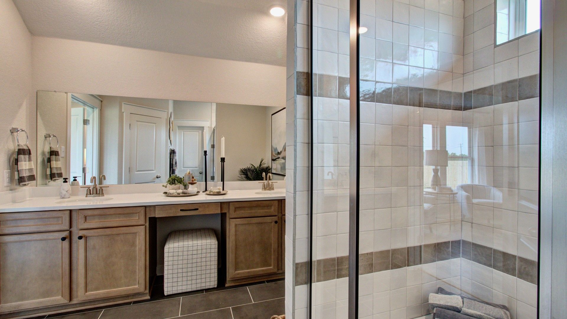 Elegant double vanity, spacious glass shower, Prairie Green. Luxurious tilework adds to modern sophistication.