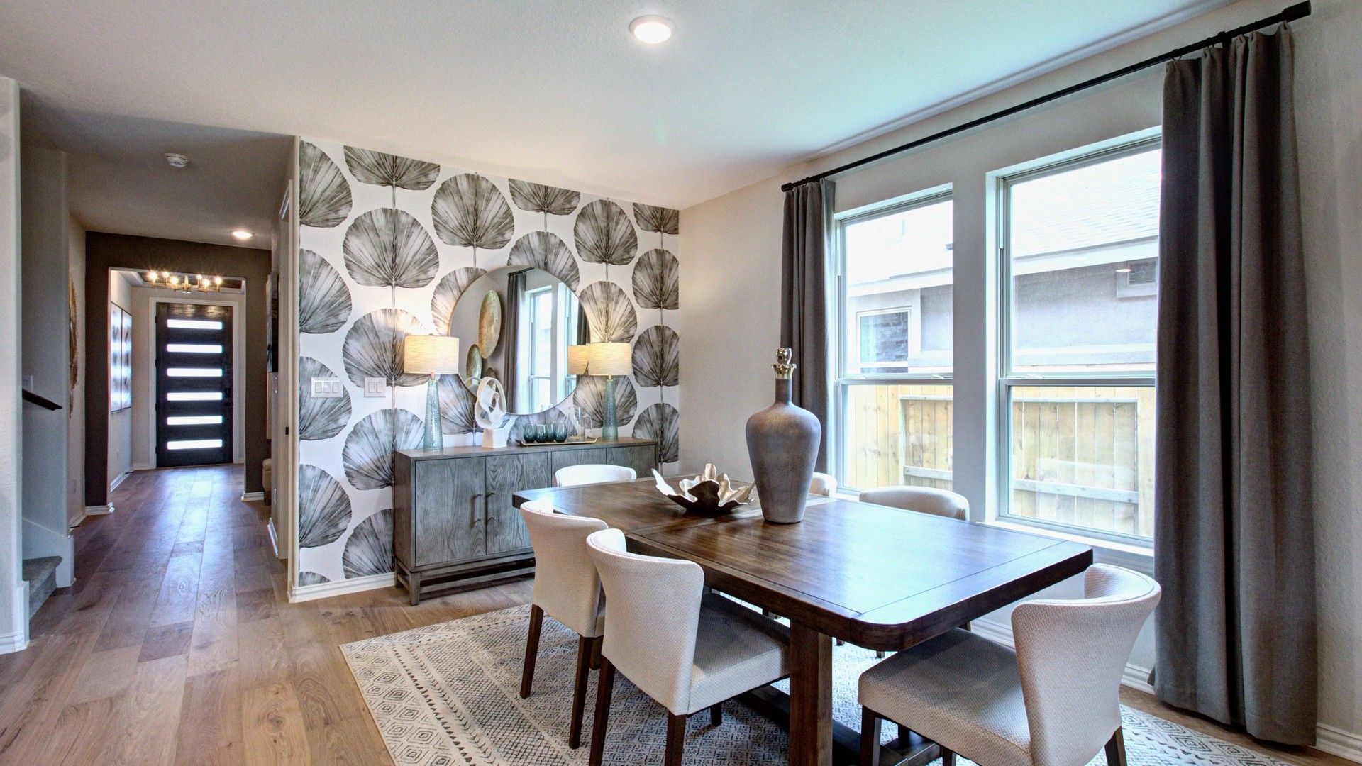 Sophisticated dining space with designer wallpaper, luxurious wood floors, and abundant natural light in Meyer Ranch.