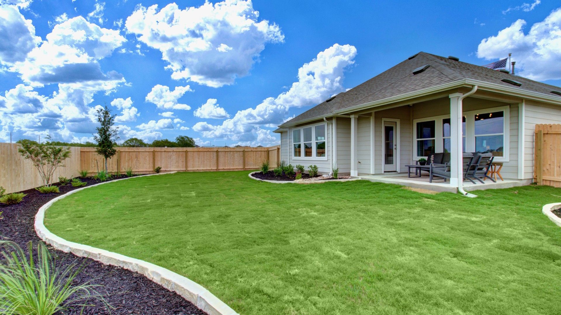 Experience elegance with a covered patio, pristine lawn, and graceful landscaping in Prairie Green.