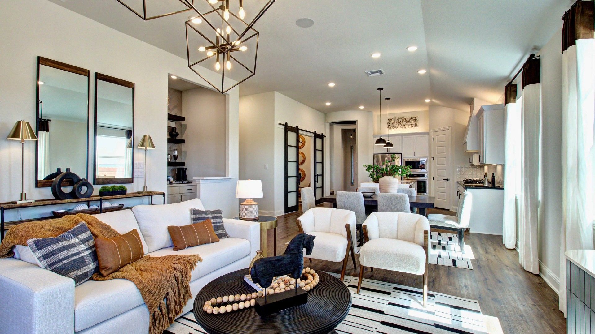 Elegant open-concept living with chic pendant lights and rich wooden flooring in Meyer Ranch, Texas.