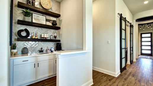 Luxurious herringbone tile and hardwood floors meet sleek dark shelving in Meyer Ranch's contemporary design.