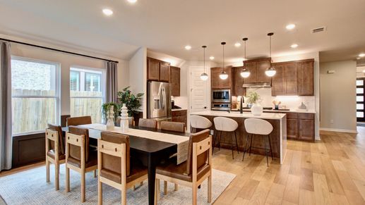 Sunflower Ridge kitchen features high-end wooden cabinetry and chic lighting. Large windows invite natural light.