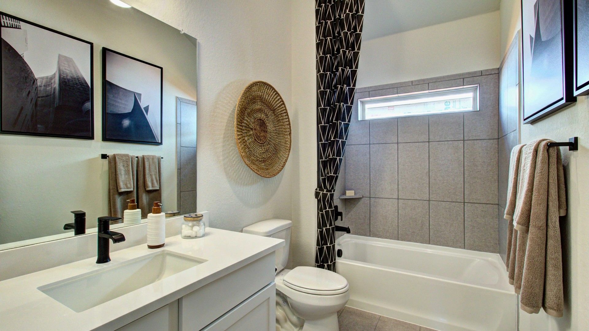 Luxurious bathroom blends modern fixtures, geometric tiles, and elegant wall art in Meyer Ranch, Texas.