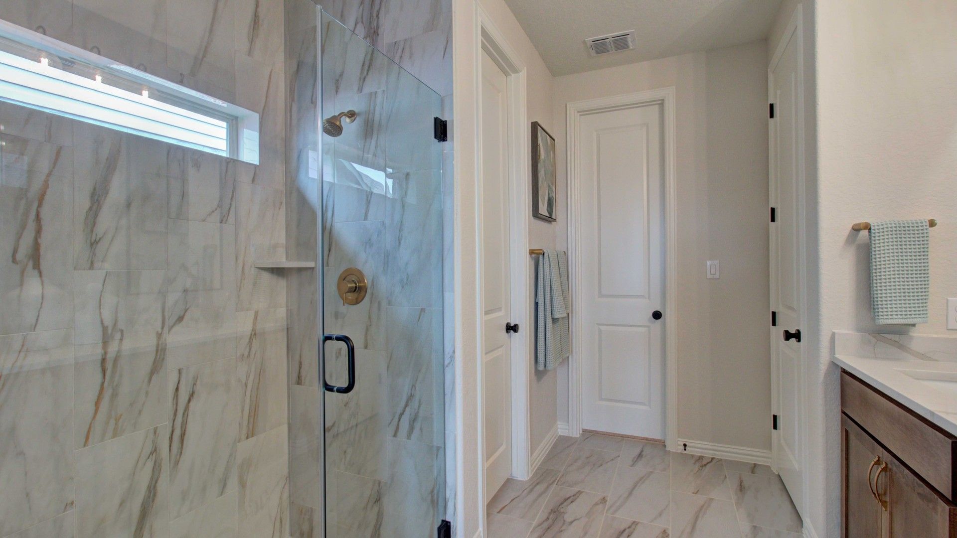 Exquisite marble tiles and gleaming glass shower embody sophistication in Meyer Ranch's Enclave.