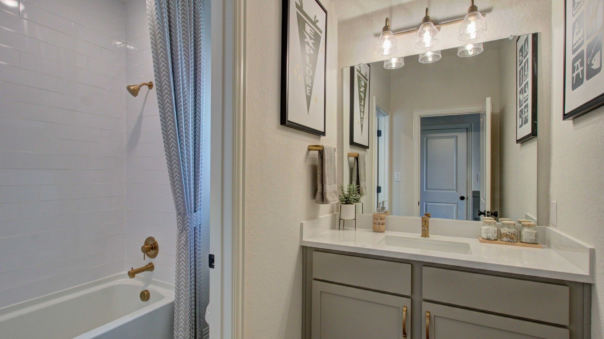 Elegant bathroom features gold fixtures, sleek gray vanity, and designer finishes in Meyer Ranch community.