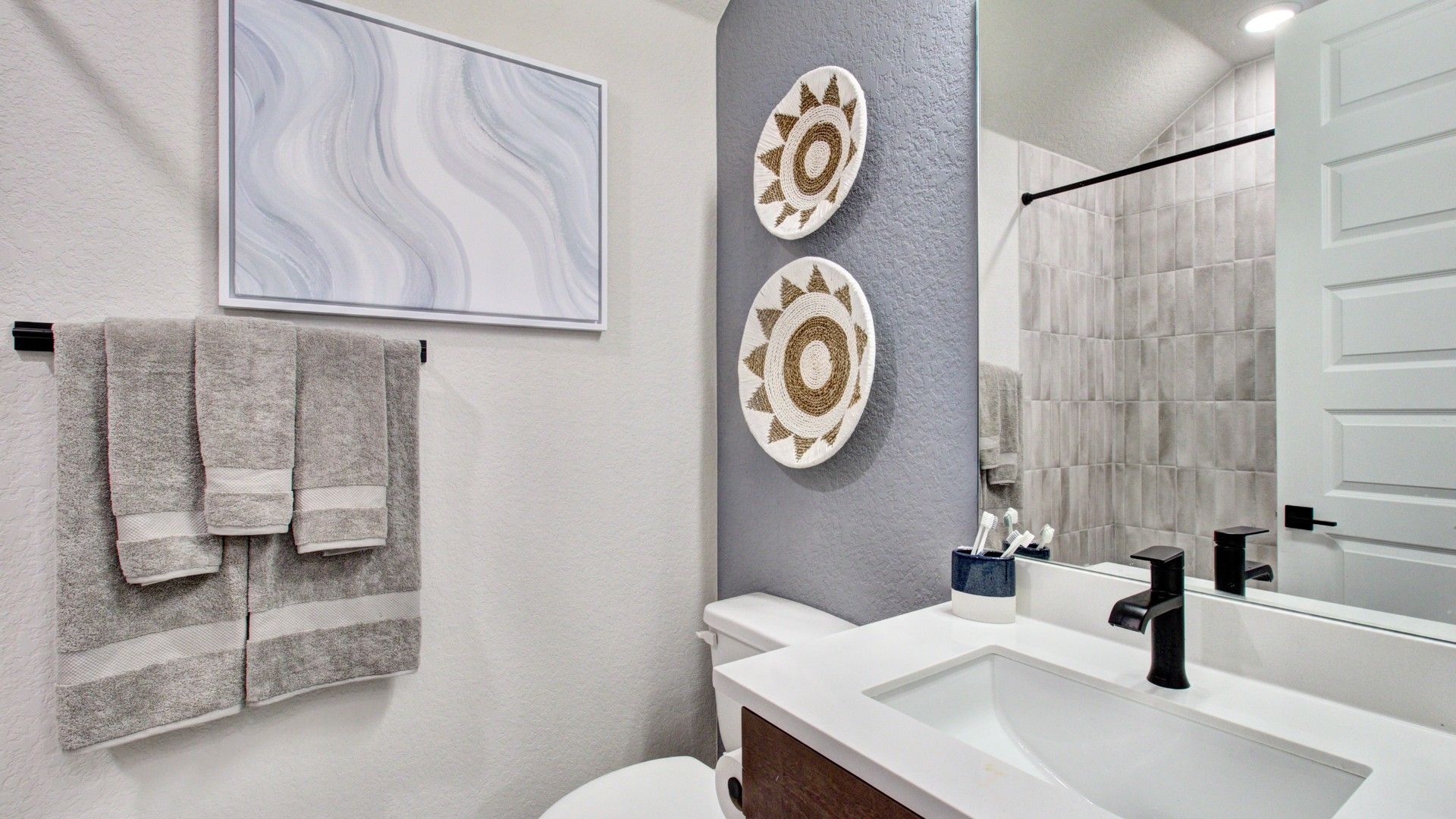 Luxurious modern bathroom at Sunflower Ridge featuring sleek fixtures and artistic wall decor.