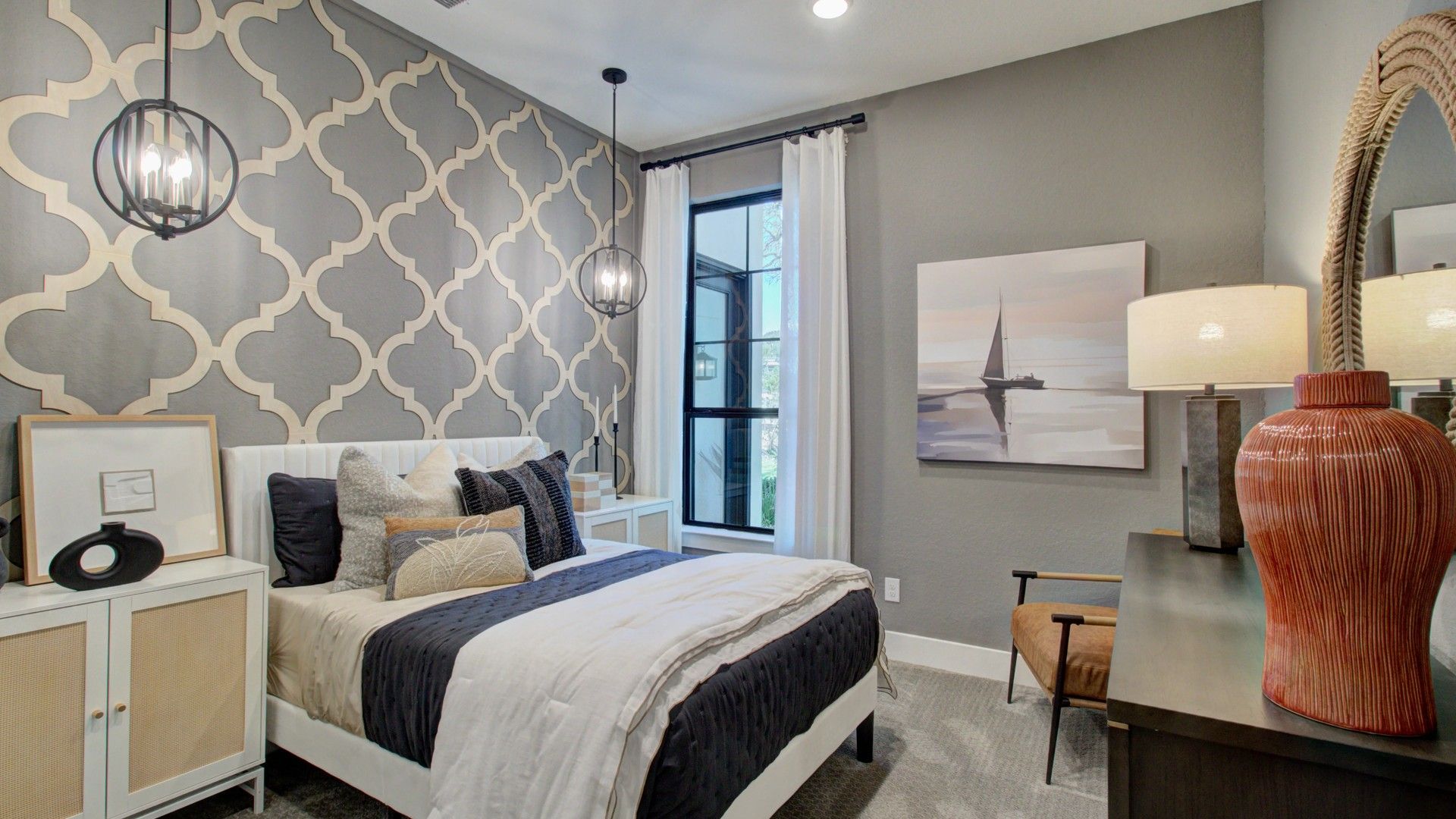 Sophisticated geometric wall and stylish pendant lighting define this exquisite Verandas at the Rim bedroom.