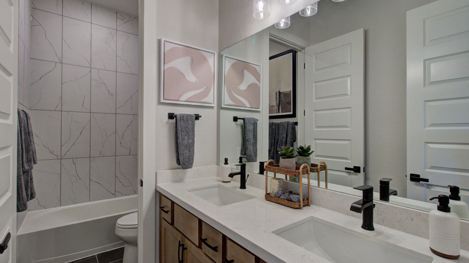 Revel in sleek marble tiles and sophisticated fixtures in this Verandas at the Rim bathroom sanctuary.