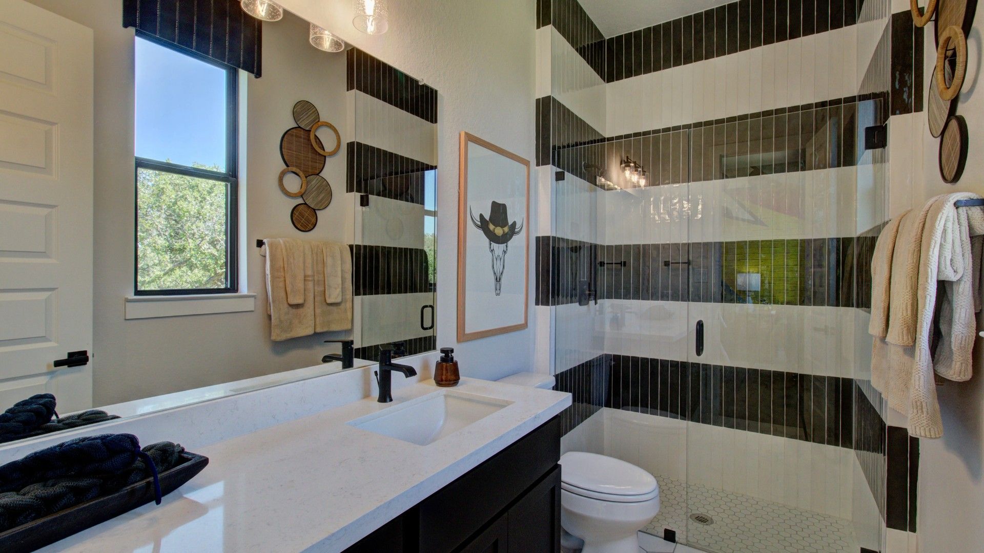 Elegantly designed striped tile shower with natural lighting enhances this sophisticated Verandas at the Rim bathroom.