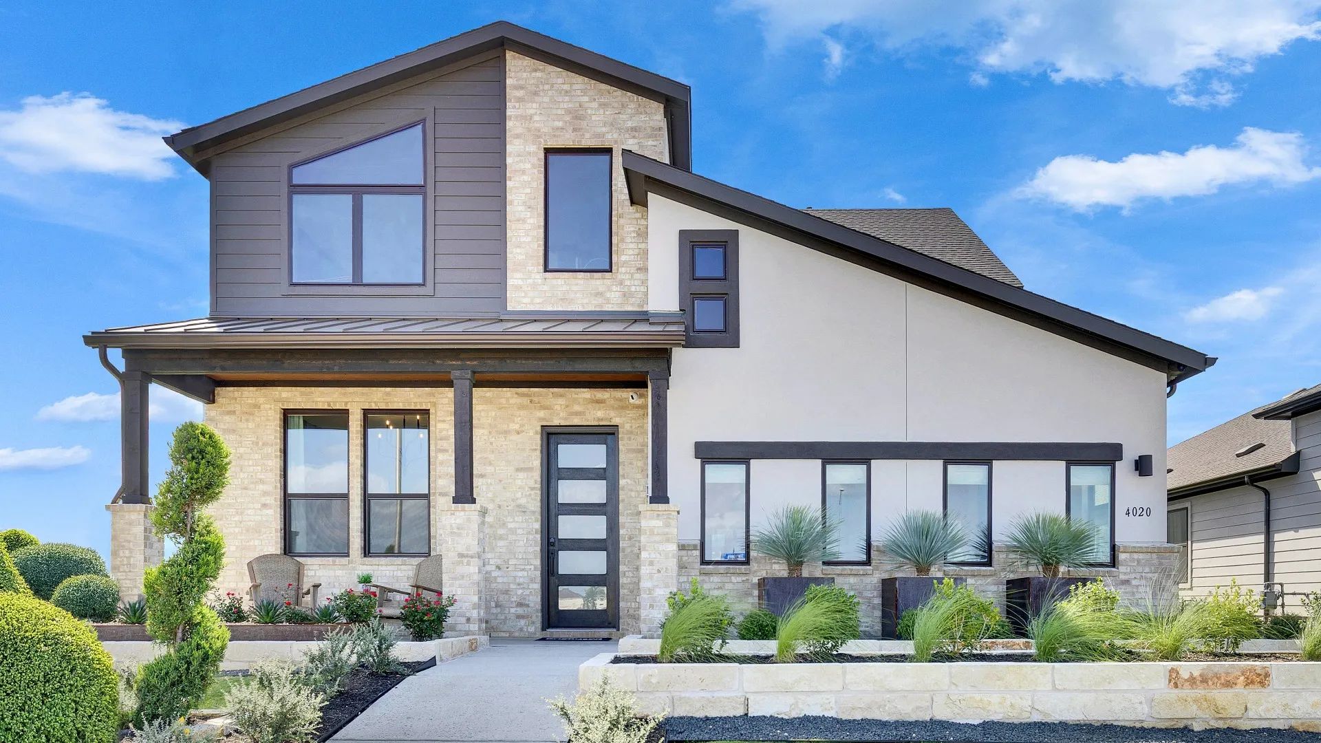 Elegant stone facade complements sleek windows in a pristine landscaped setting at Lakeside Meadows.