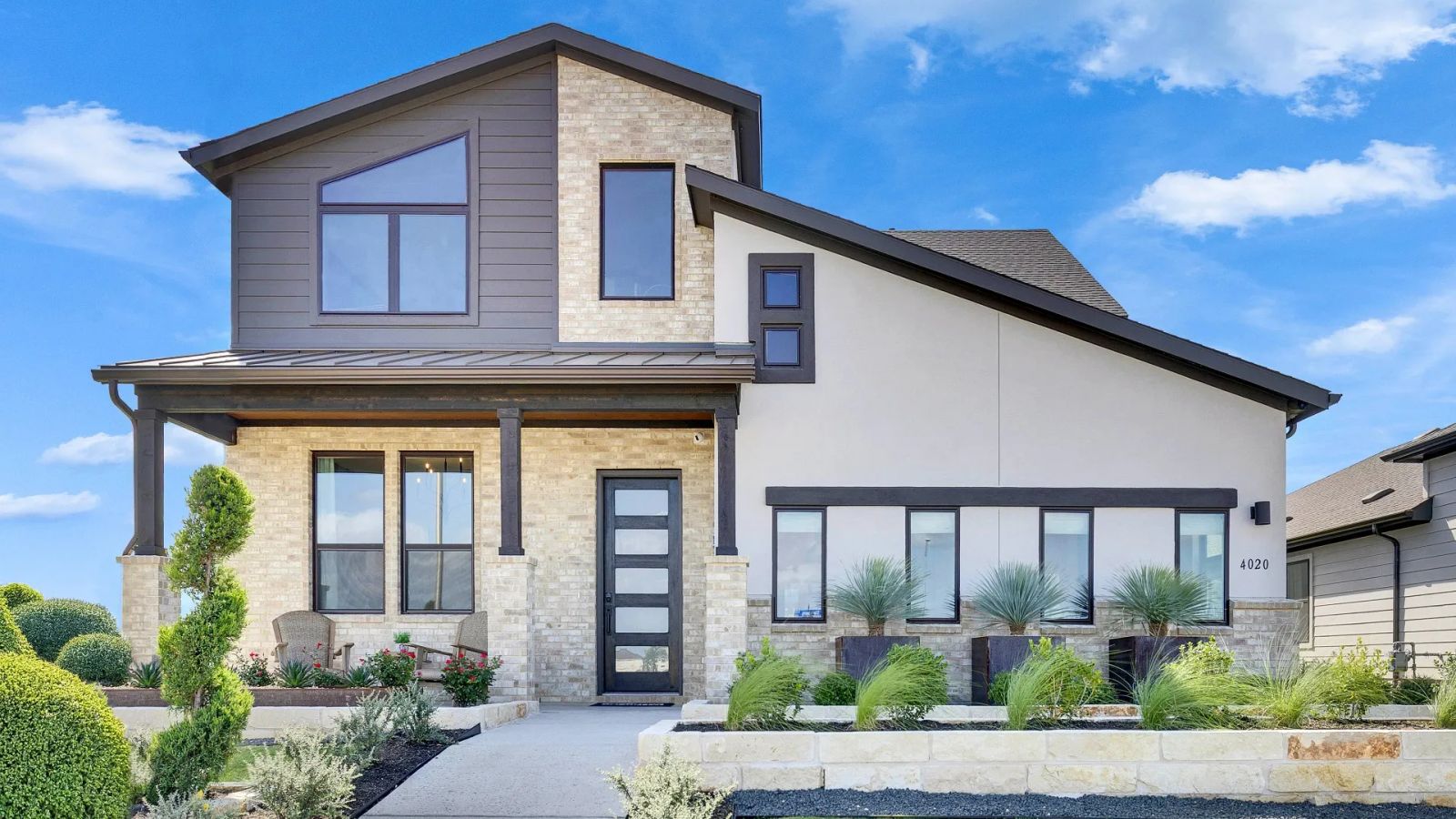 Elegant stone facade complements sleek windows in a pristine landscaped setting at Lakeside Meadows.