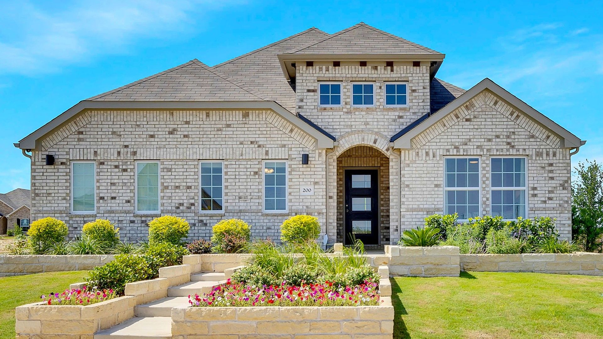 Distinctive brick facade and arched entrance embody elegance. Lush landscaping enhances the Hunters Glen allure.