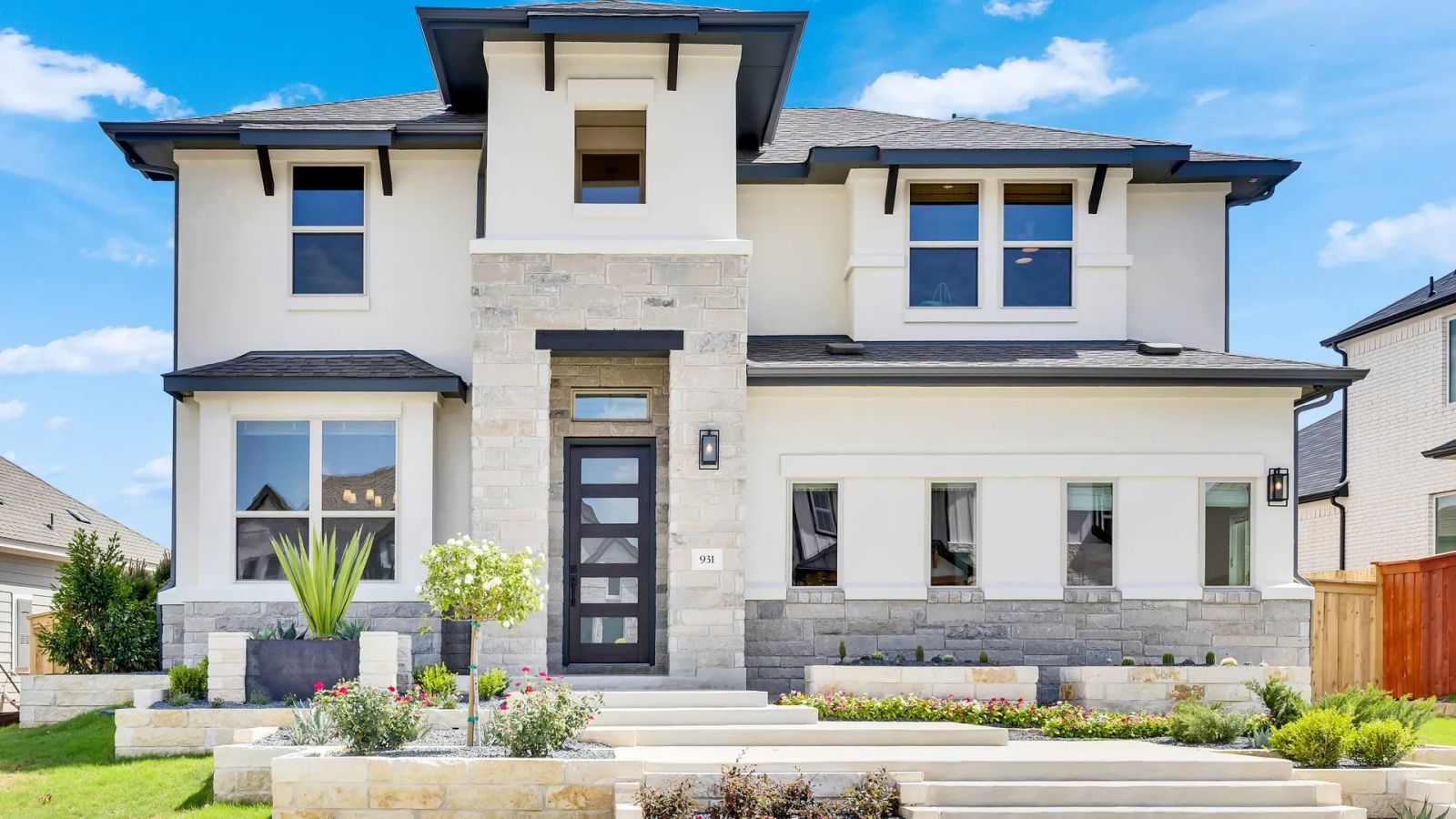 Exquisite stone façade and expansive windows define this stunning Sunfield community residence.