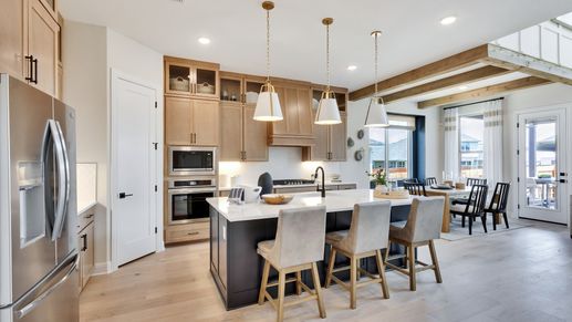 Sunfield's kitchen boasts a sleek island, premium wood cabinetry, and elegant pendant lighting.