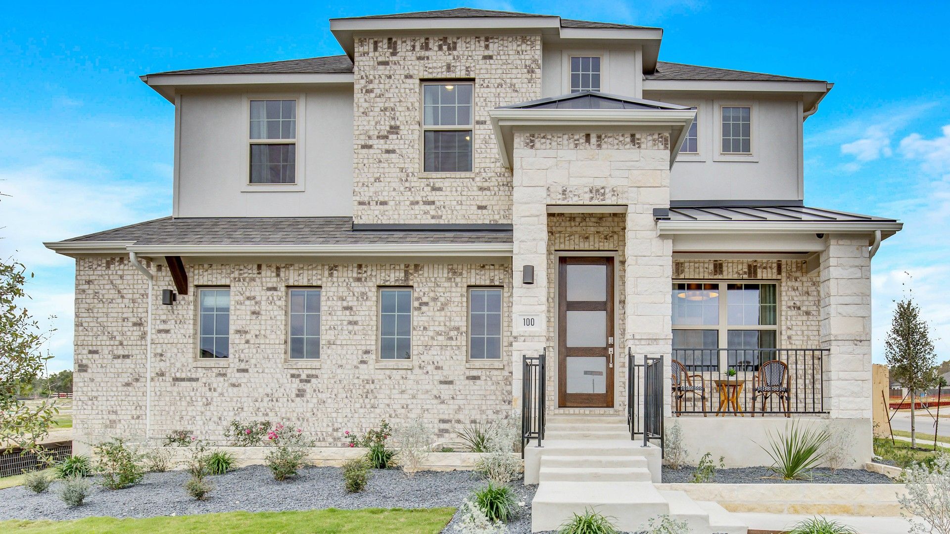 Luxurious brick facade boasts large windows and elegant porch in Opal Ranch, Texas, exuding refined modernity.