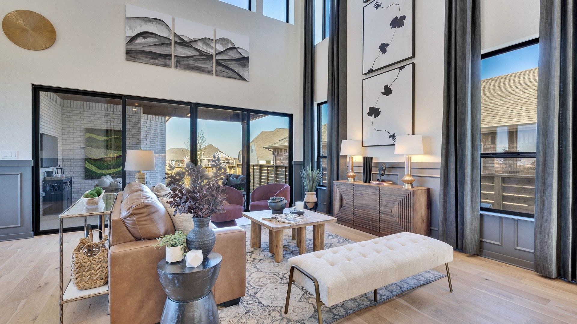 Experience refined living with high ceilings, abstract art, and expansive windows in Flora community.