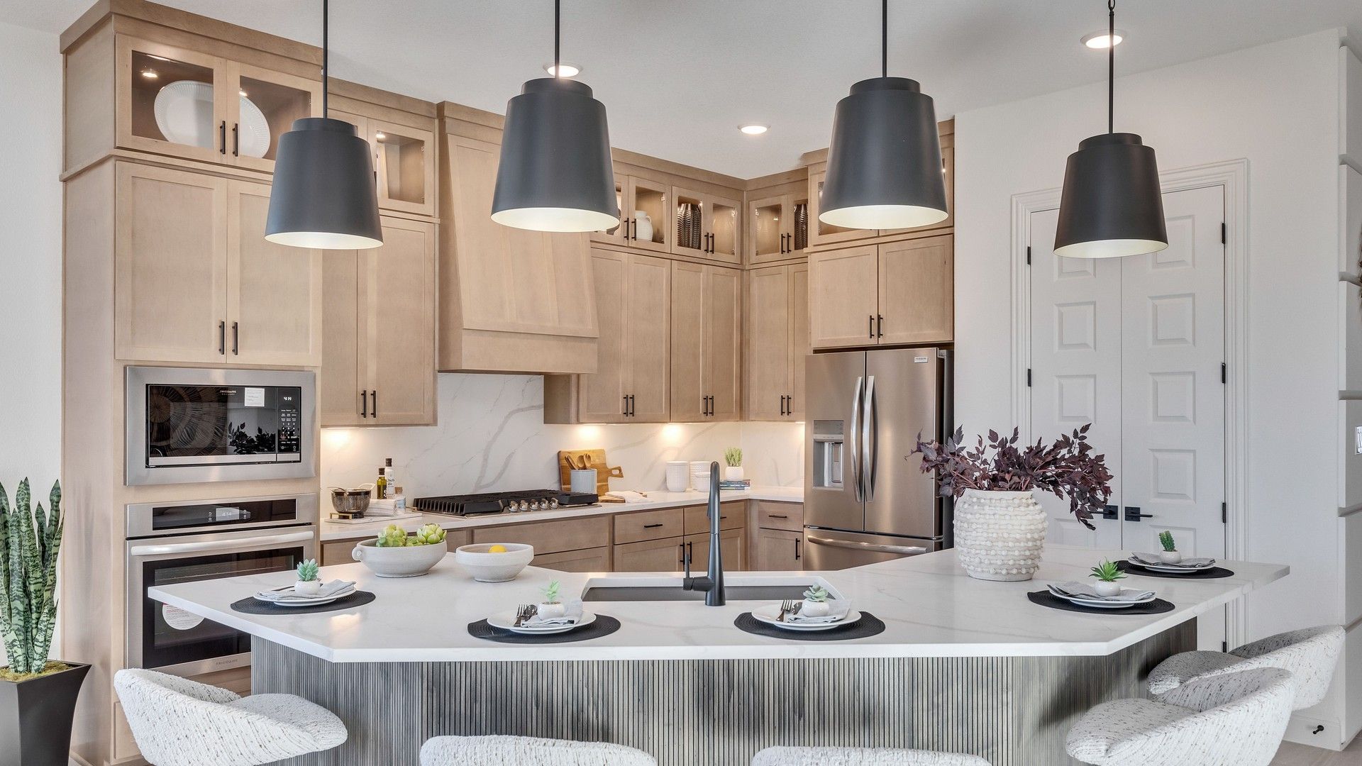 Elegant Creeks Crossing kitchen features marble counters, premium wood cabinets, and modern lighting.