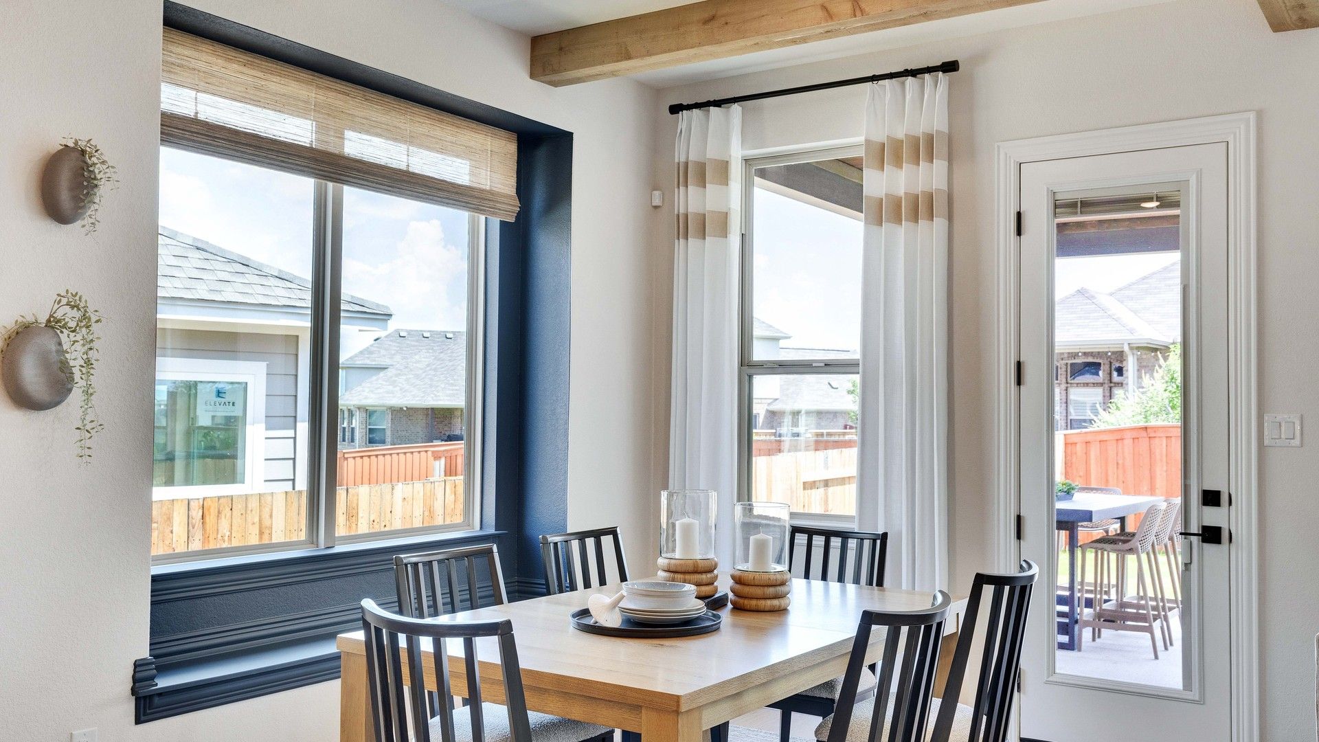 Elegant wooden beams and expansive windows define this Sunfield dining room in Buda, Texas.