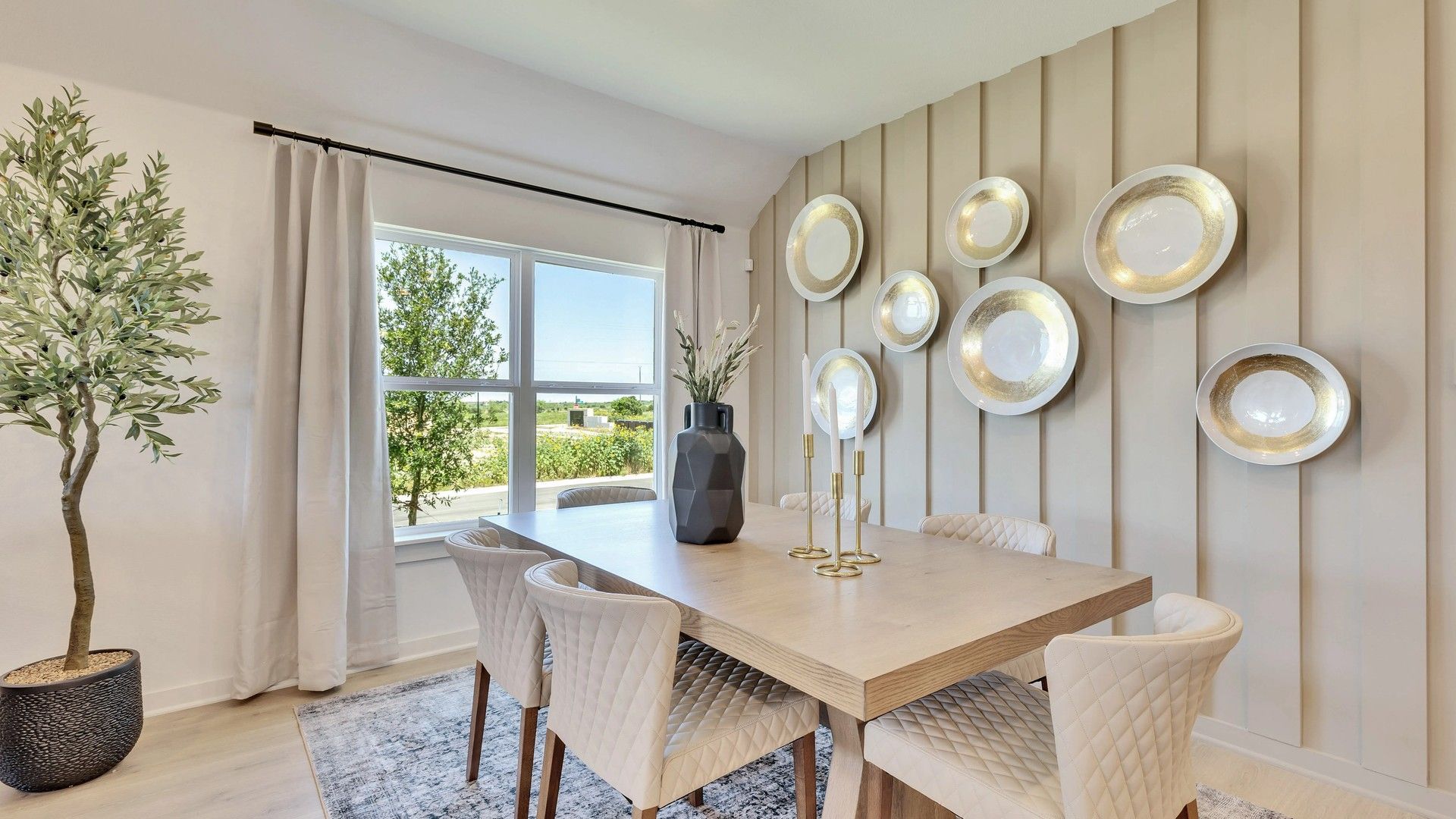 Experience luxury with quilted chairs, a light wood table, and stylish wall art in Hunters Glen.