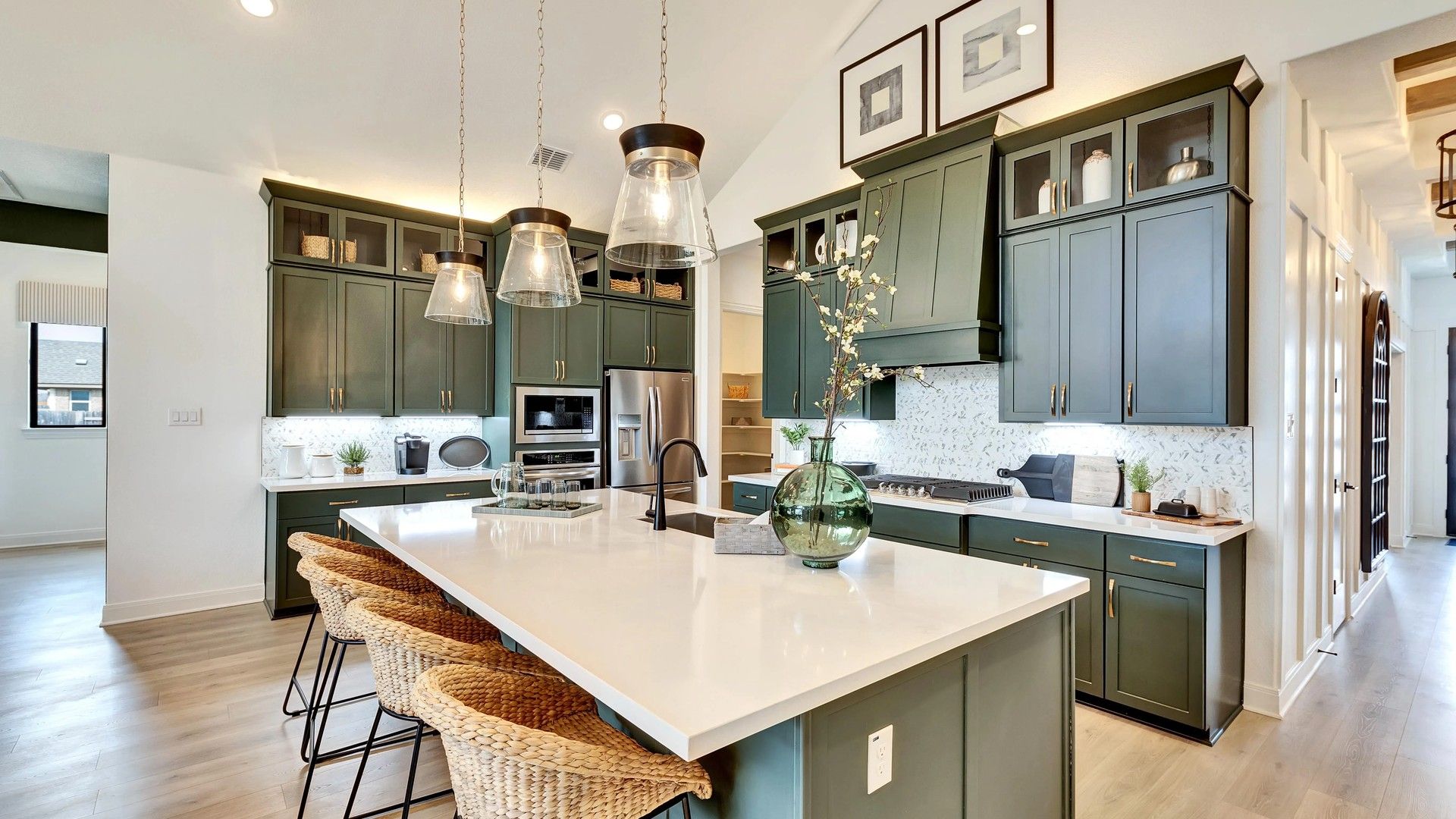 Elegant quartz countertops and distinctive green cabinetry enrich this Hawkes Landing kitchen.
