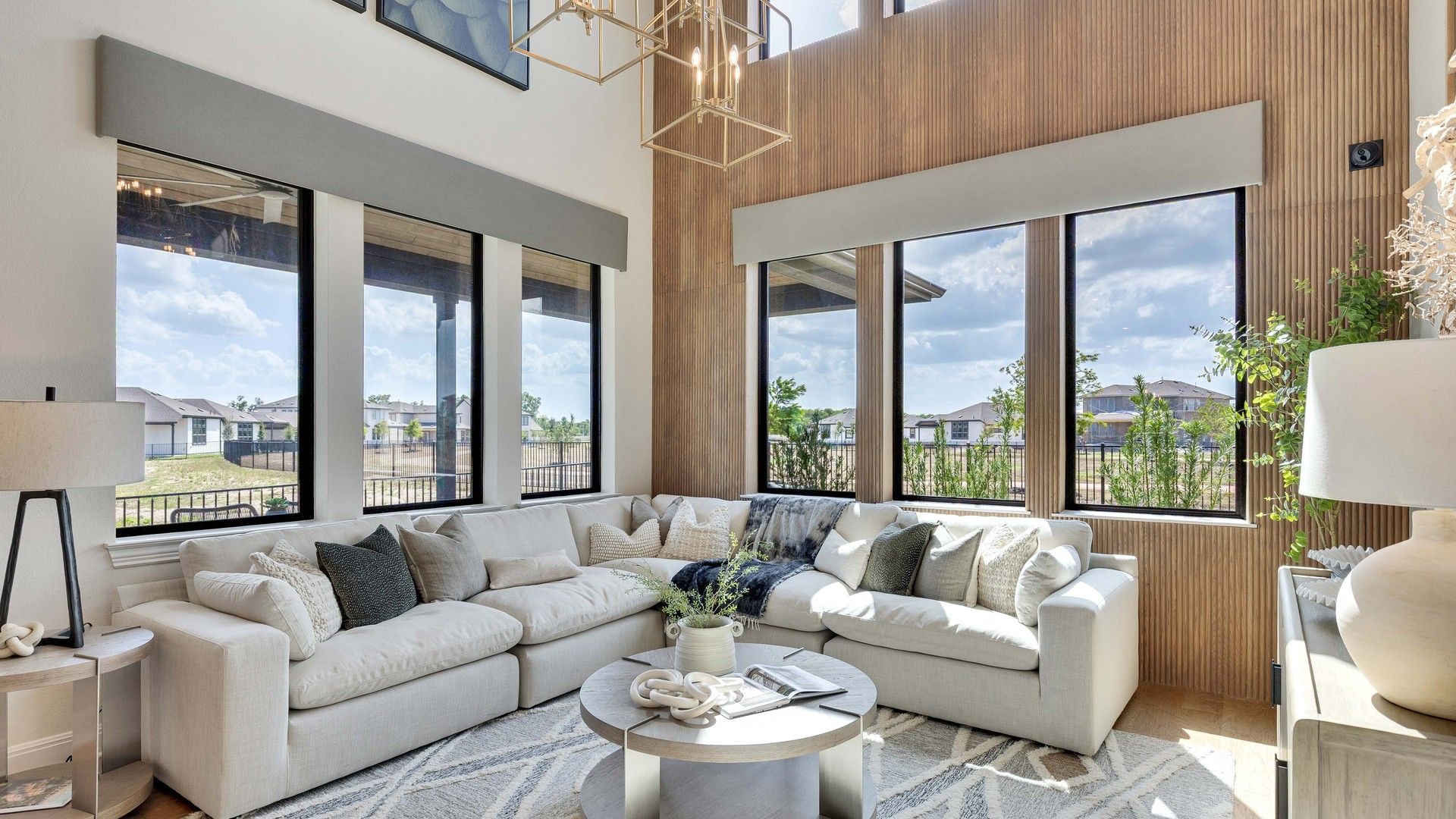 Revel in the grandeur of this Lakeside Meadows living room, boasting soaring windows and chic wooden accents.