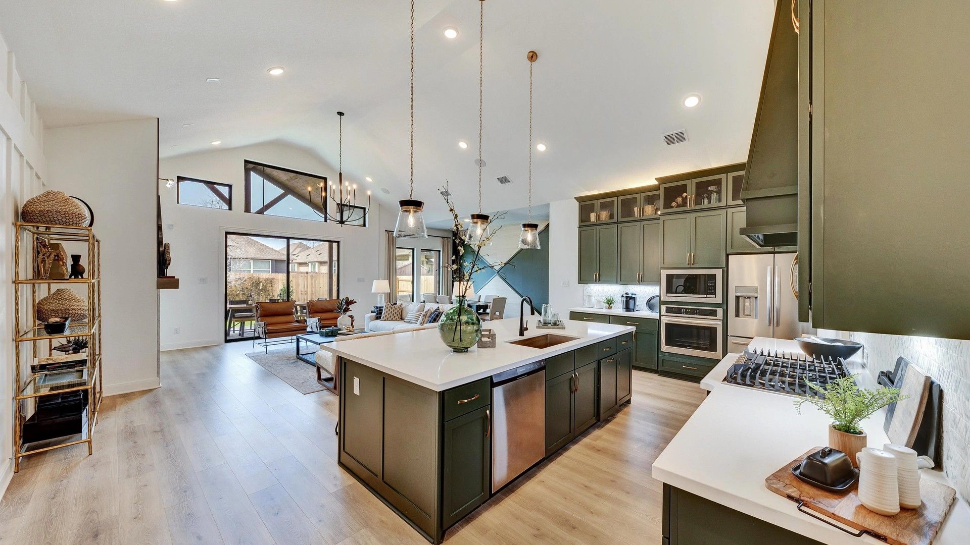 Luxurious Hawkes Landing kitchen with striking green cabinetry, high ceilings, and chic lighting.